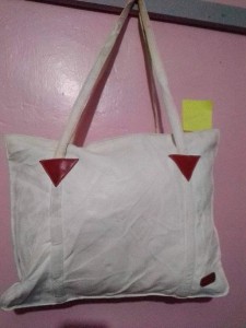 White hand bag with straps for both hand and shoulders.