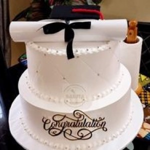 Medium graduation cake decorated with white creamy and black cream with graduation hat